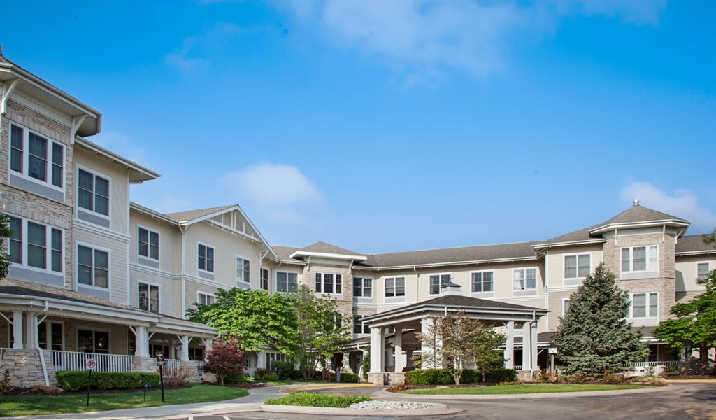 A modern residential building with well-maintained landscaping and a clear blue sky.