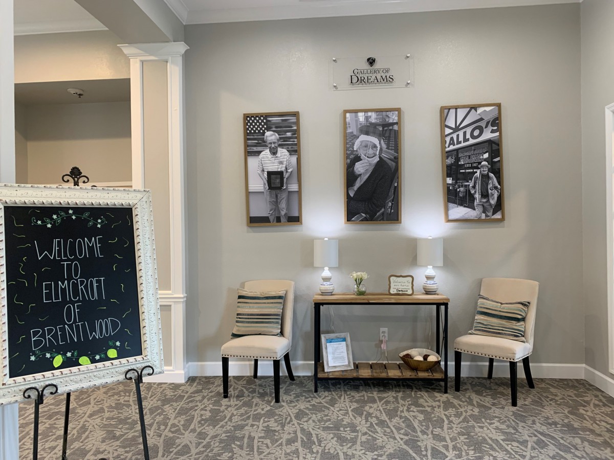 A cozy lobby with seating chairs, wall art, and a console table.