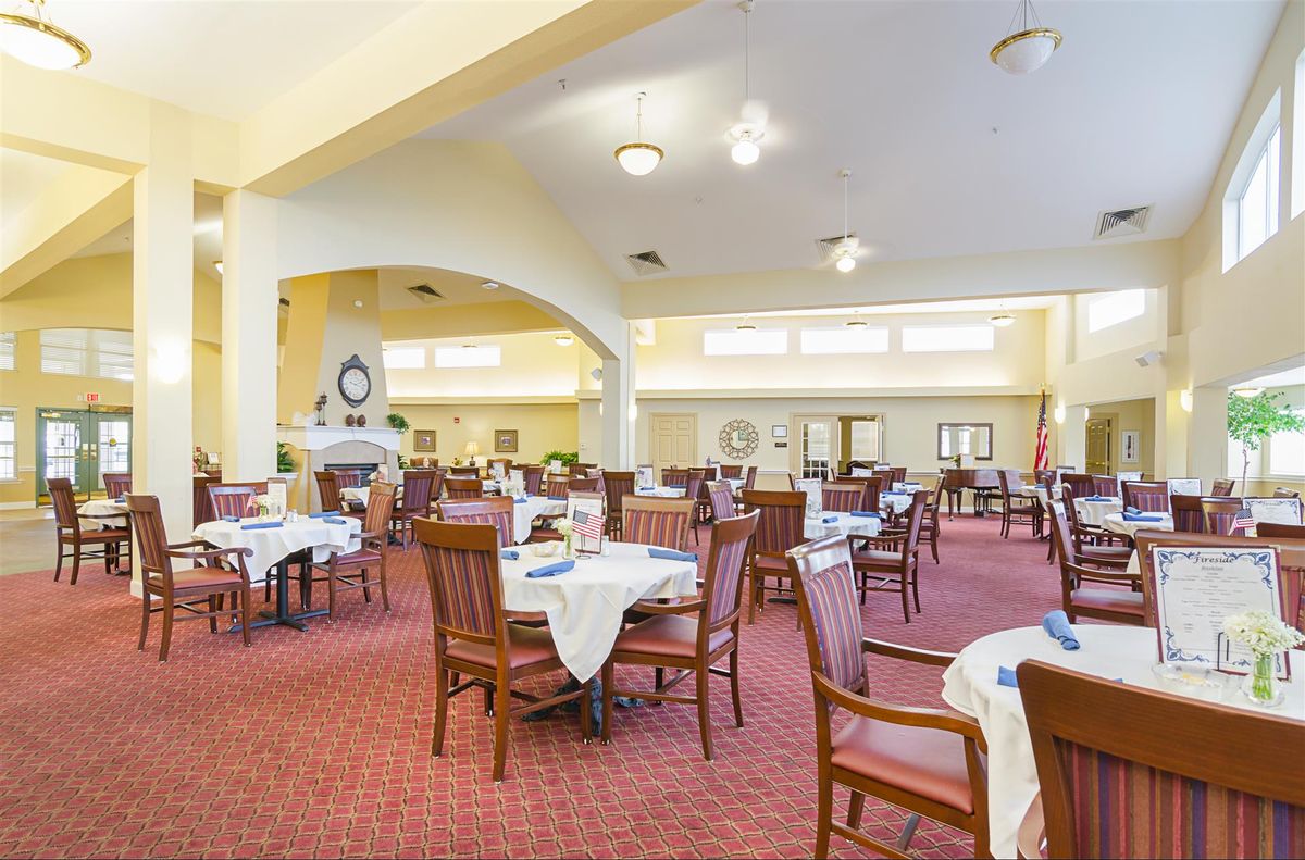 A spacious and well-lit dining room with neatly arranged tables and chairs.