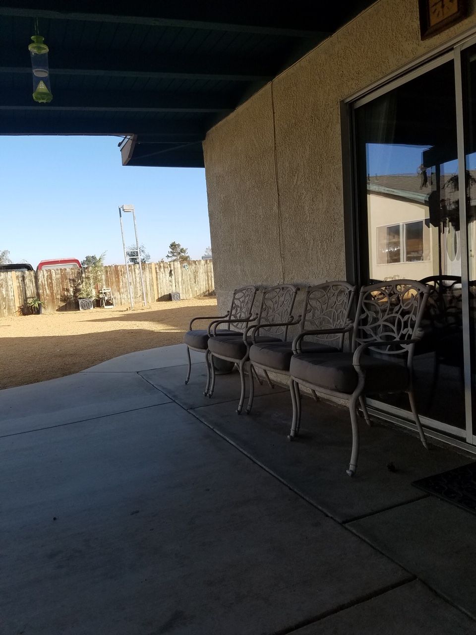 A sunny patio with chairs lined up outside a building.