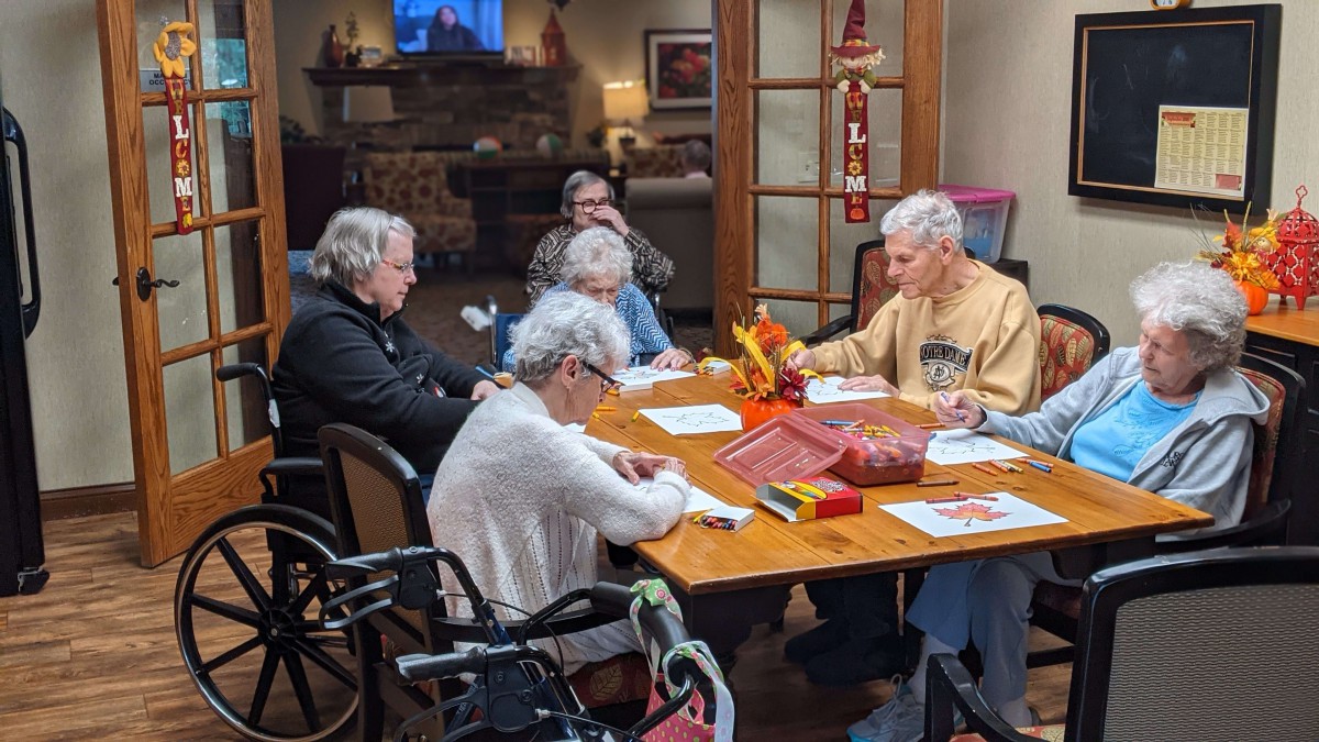 A group of elderly people playing a game together indoors, showcasing community and social interaction.