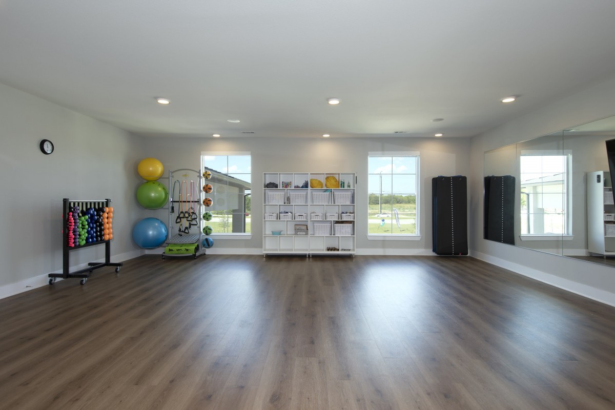 A bright and spacious exercise room equipped with yoga balls and mirrors.