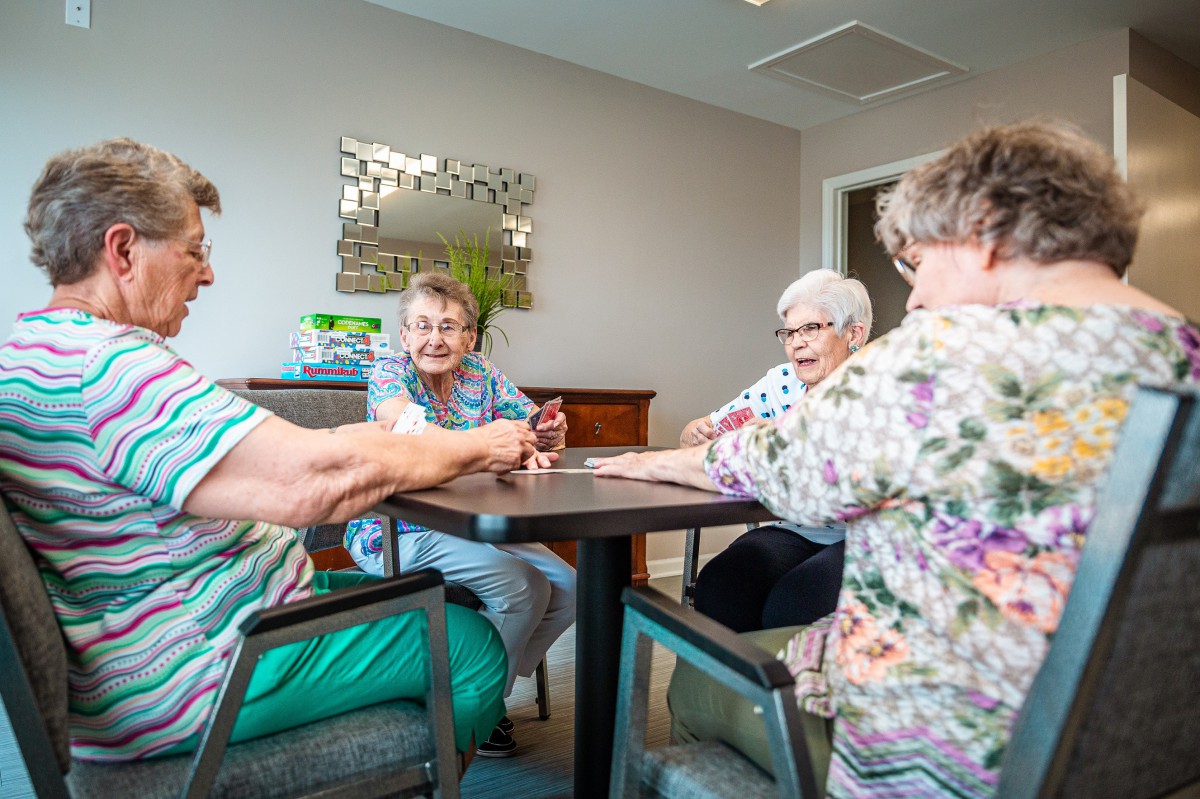 A group of seniors enjoying a card game together in a cozy room.