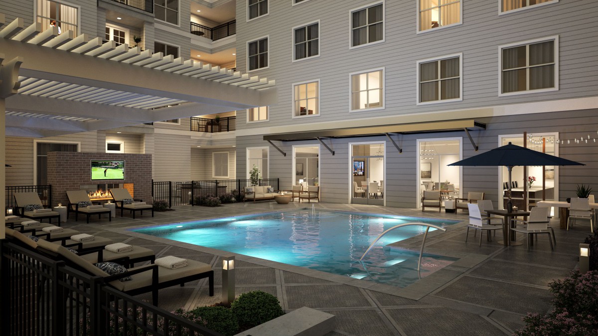 A beautifully lit swimming pool in a luxury hotel courtyard at night.