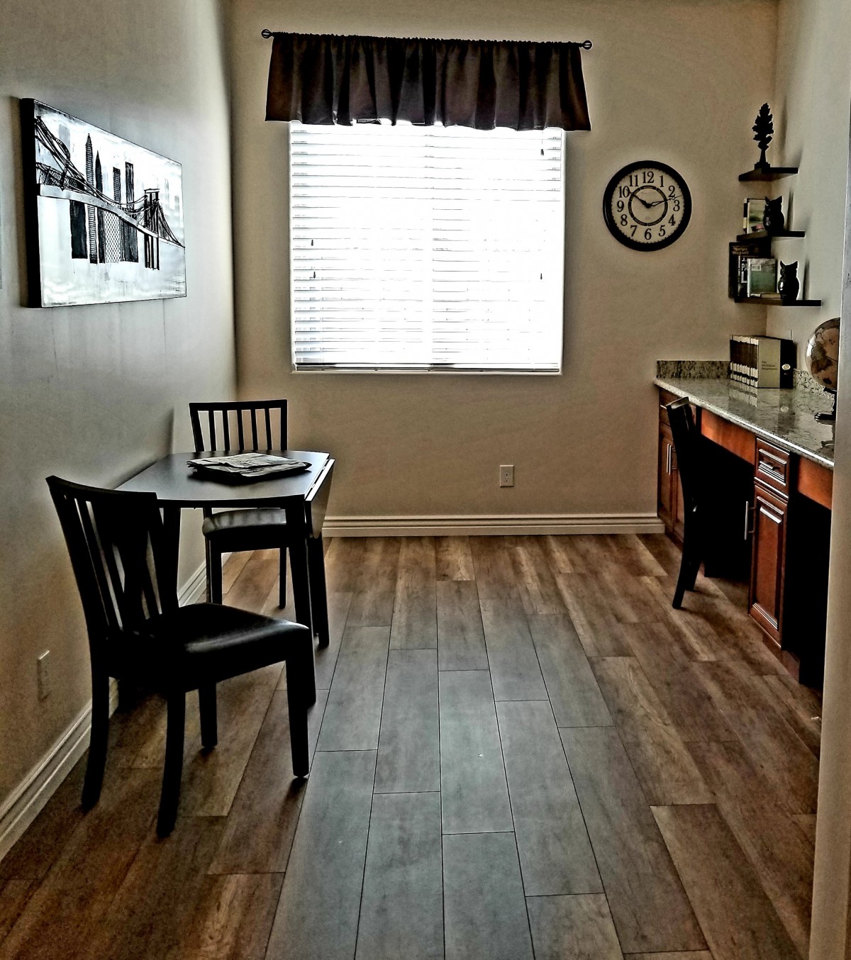 A cozy kitchen nook with a small dining table and chairs, featuring a window that lets in natural light.