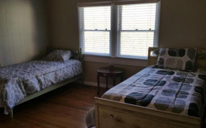 A cozy bedroom with two single beds and a window letting in natural light.