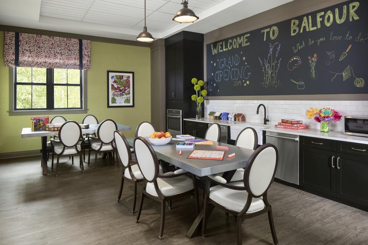 A modern dining area with a welcoming atmosphere, featuring a table, chairs, and a kitchenette.