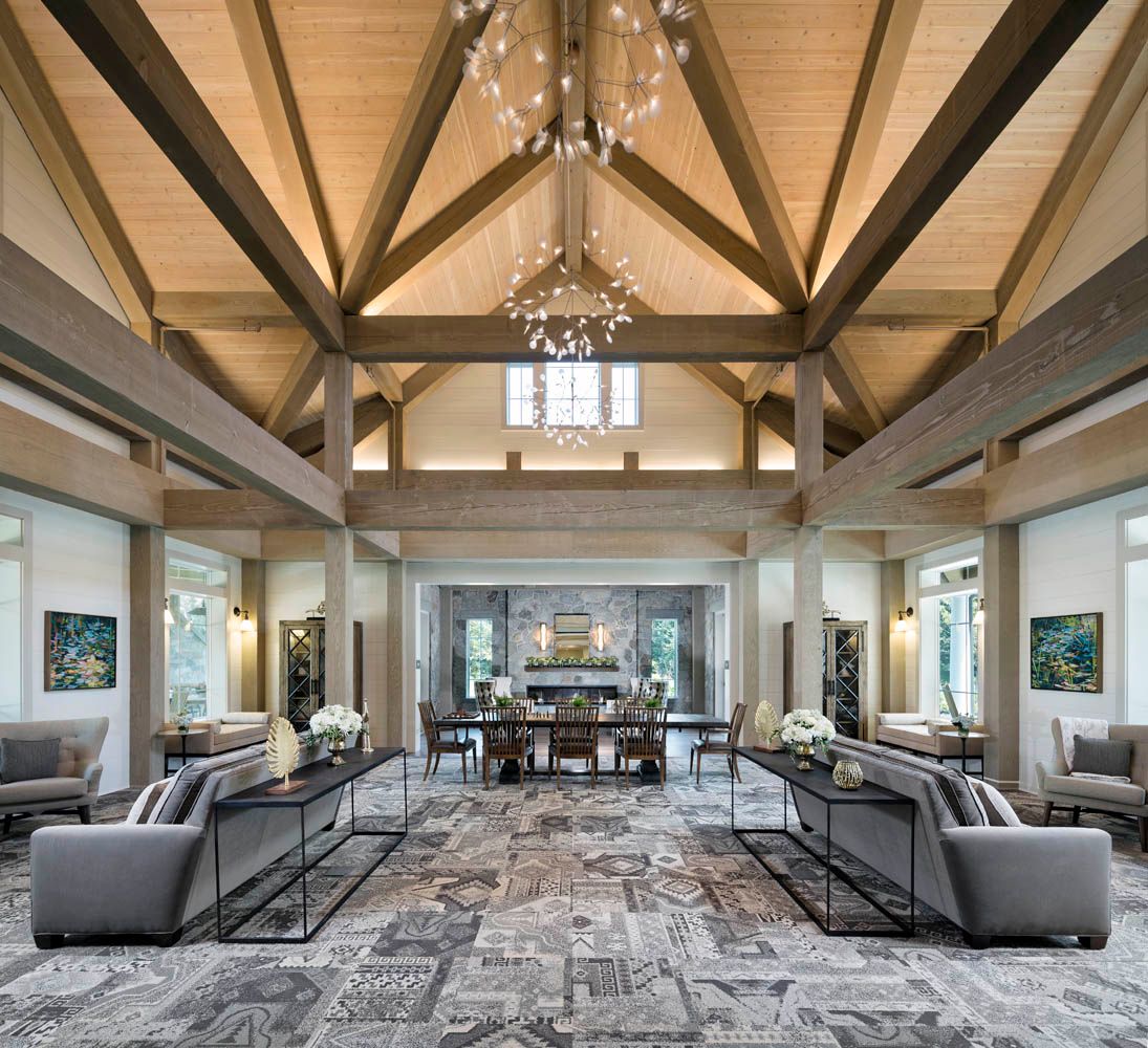 A luxurious and spacious living room with a vaulted ceiling and elegant chandelier.