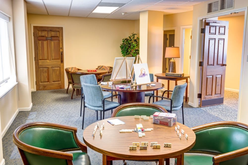 A cozy game room with multiple tables and chairs set up for board games.