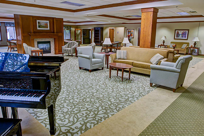 A spacious hotel lobby with comfortable seating and a grand piano.