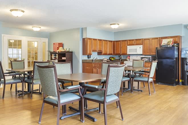 A spacious kitchen and dining area with wooden cabinets, tables, and chairs.