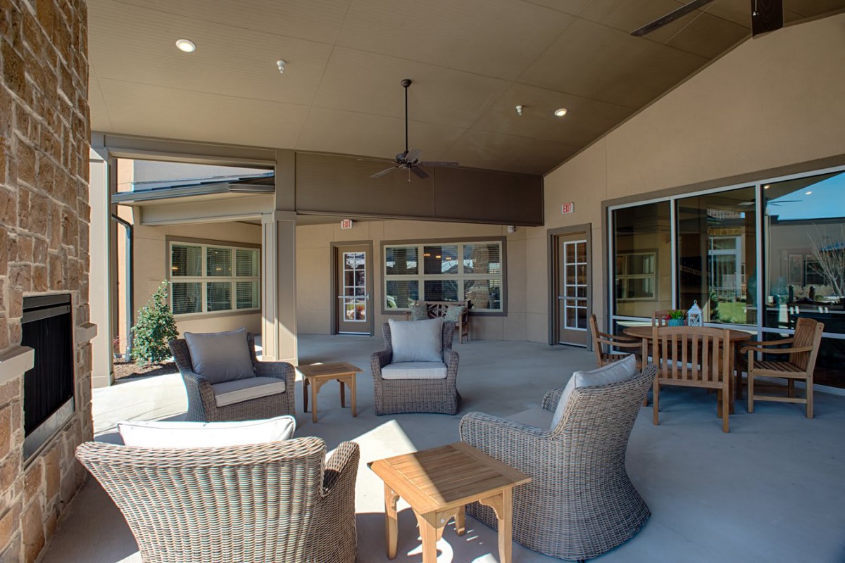 A cozy covered patio area with wicker chairs and a table for relaxation.