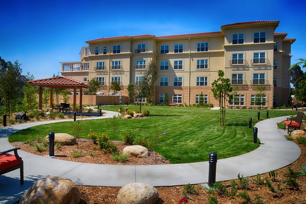 A residential building with a landscaped garden and lawn area.