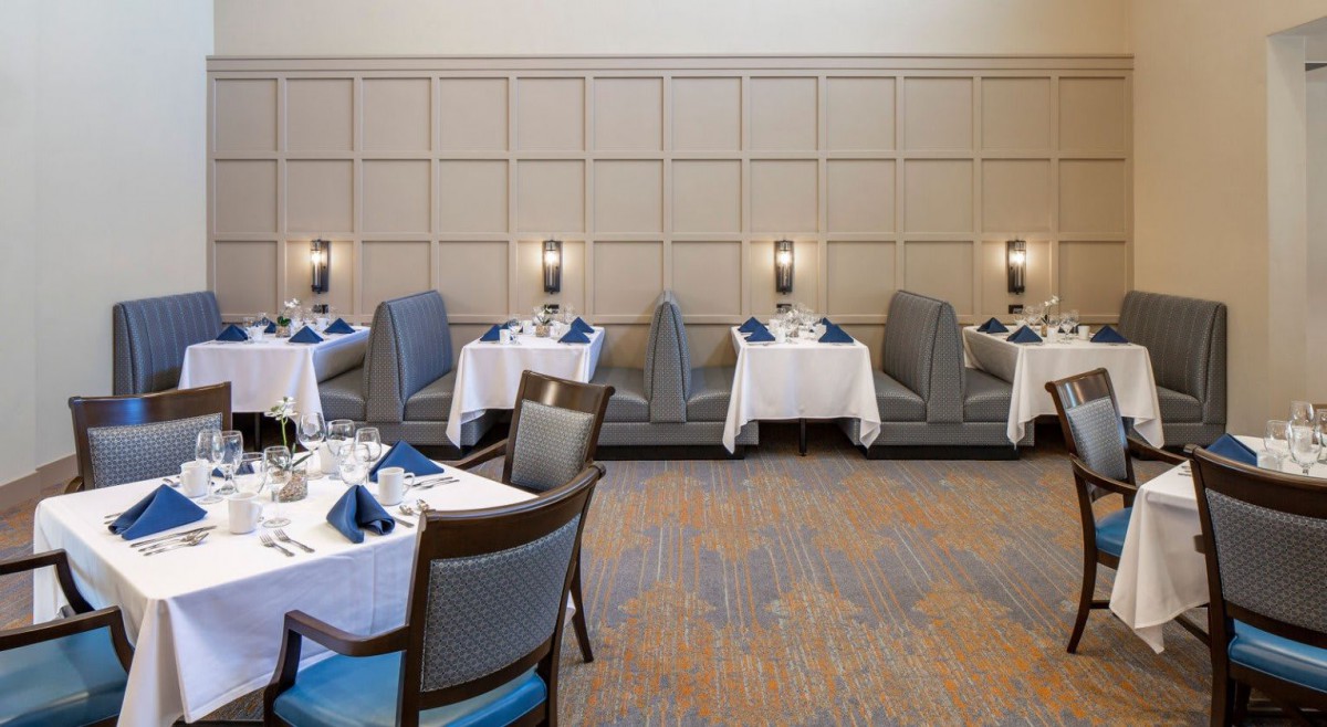 An elegant restaurant dining area with booth seating and neatly arranged tables.