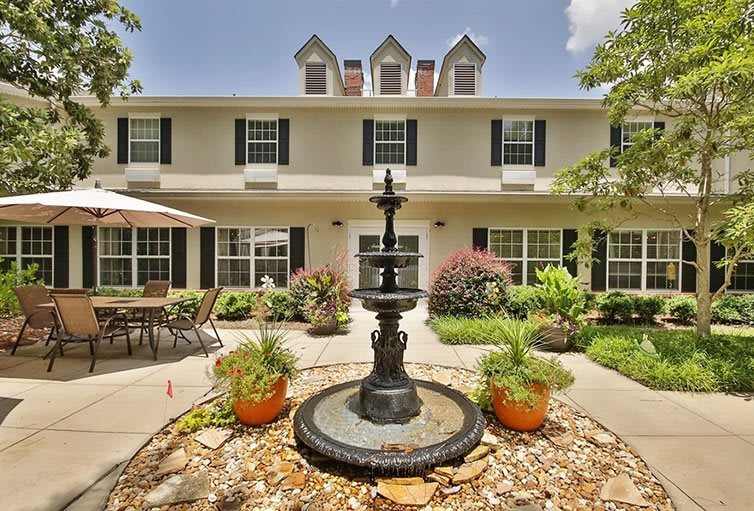 A charming house with a central fountain and well-maintained garden.