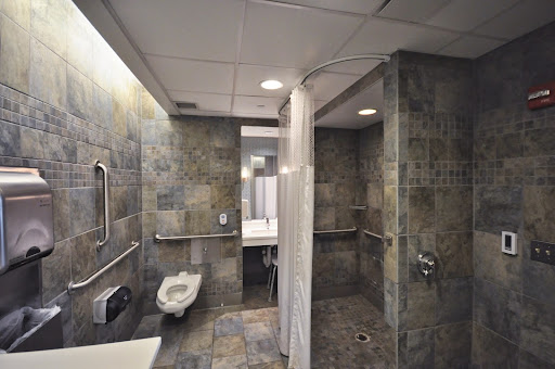 A modern accessible bathroom featuring a shower area with tiled walls.