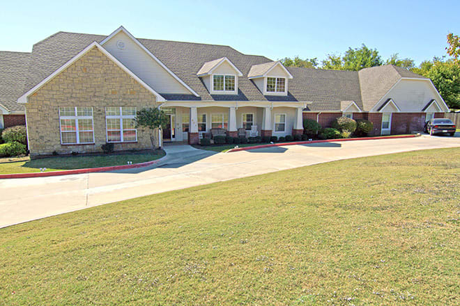A spacious suburban house with a well-maintained lawn and driveway.
