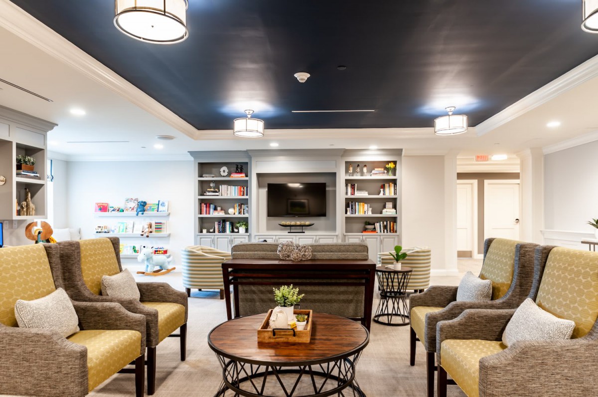 A modern living room with comfortable seating, bookshelves, and a television.