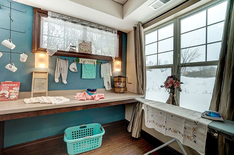 A cozy laundry room with a clothesline by the window and a laundry basket on the floor.