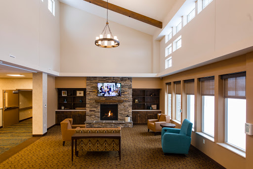 A spacious and inviting lobby area featuring a fireplace, comfortable seating, and ample natural light.