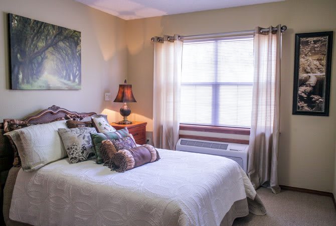 A cozy bedroom with a neatly made bed and soft lighting.