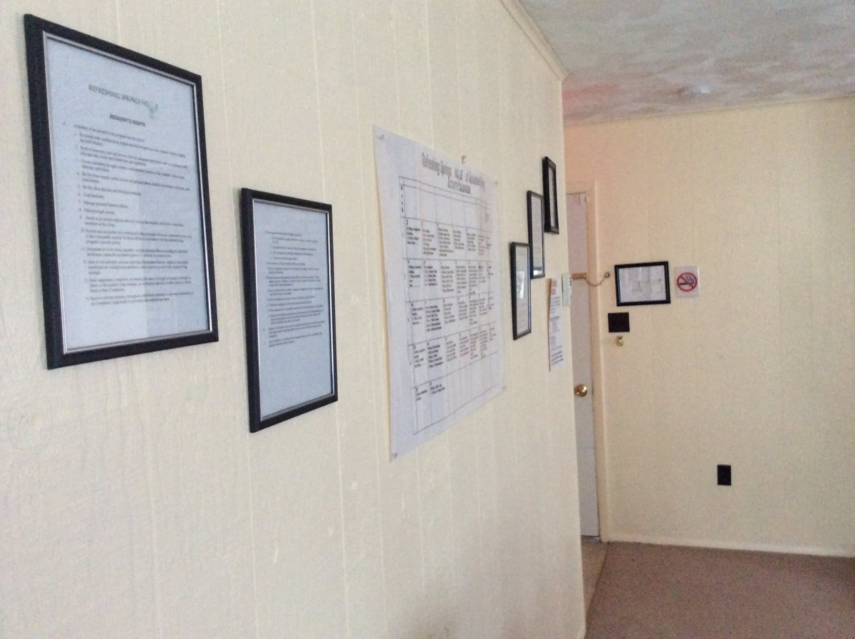 A hallway decorated with framed documents and wall art.