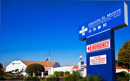 A view of a hospital with emergency signage under a clear blue sky.
