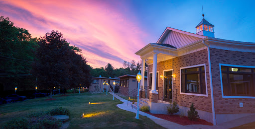 A beautifully illuminated building beneath a vibrant sunset sky.