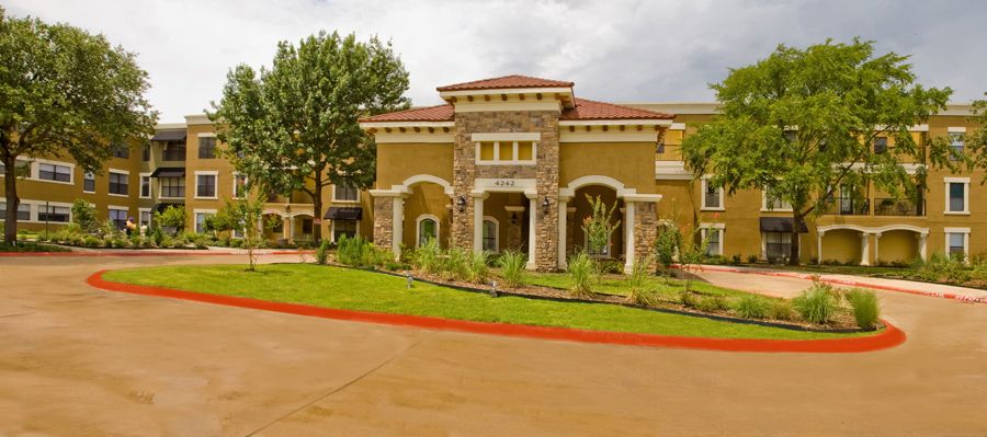 A stylish building with a landscaped entrance and surrounding greenery.