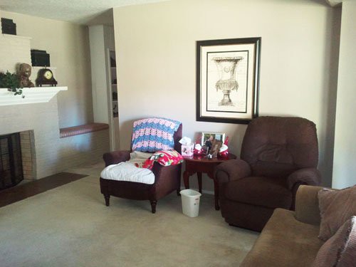 A cozy living room with armchairs and a framed artwork on the wall.