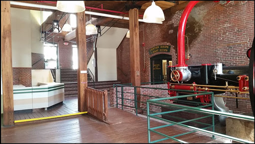 The interior of a historic industrial facility featuring exposed brick walls and vintage machinery.