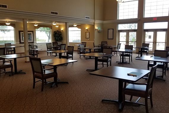An empty dining room with neatly arranged tables and chairs.