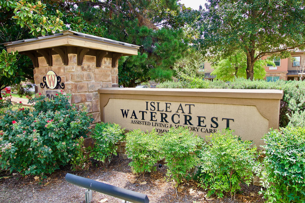 Entrance sign for Isle at Watercrest, surrounded by lush greenery.