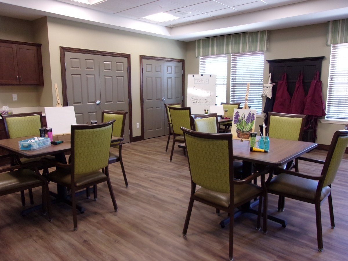 A well-lit room with tables and chairs arranged for meetings or gatherings.