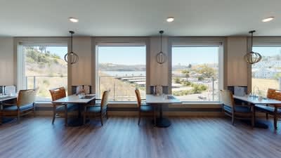 A modern dining area with large windows providing a view of the outdoors.
