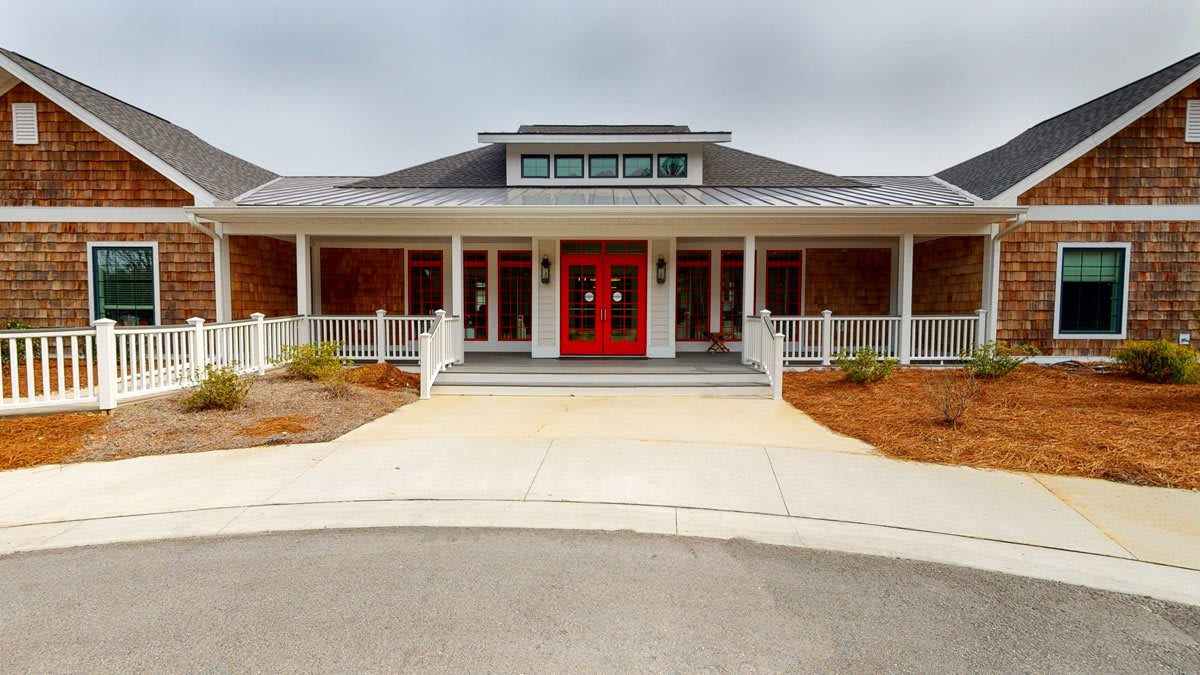 A welcoming building entrance with bold red doors and a spacious porch.