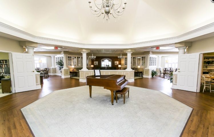A spacious and elegant lobby with a grand piano in the center.