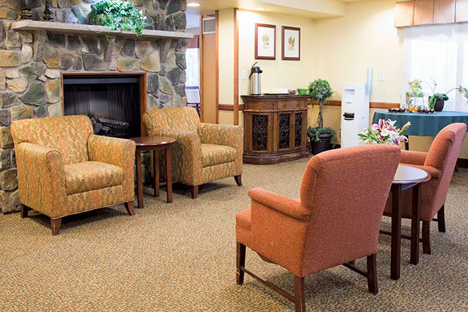 A cozy waiting room with comfortable chairs and a fireplace.