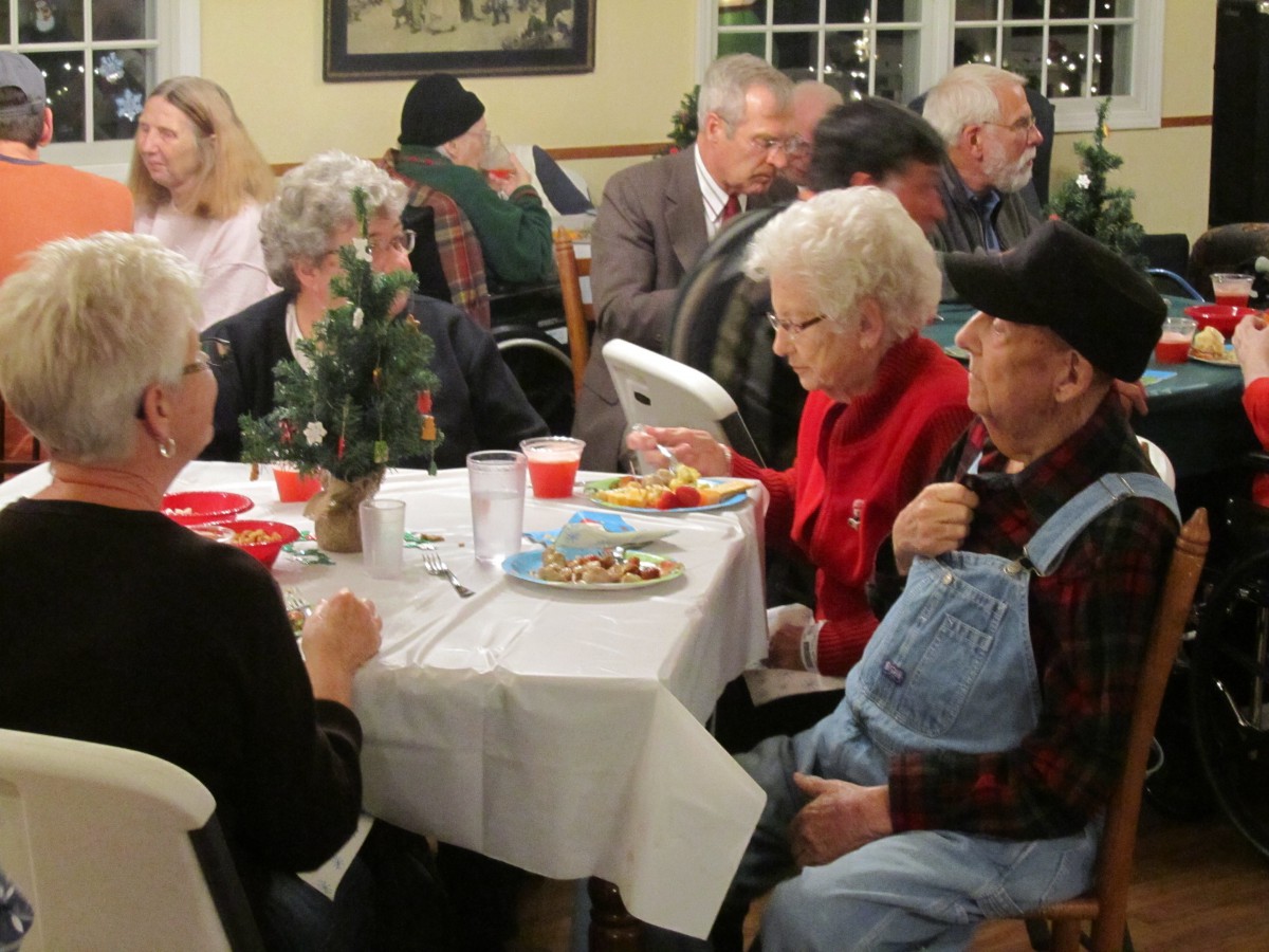 A group of seniors enjoying a dinner gathering at an indoor event.