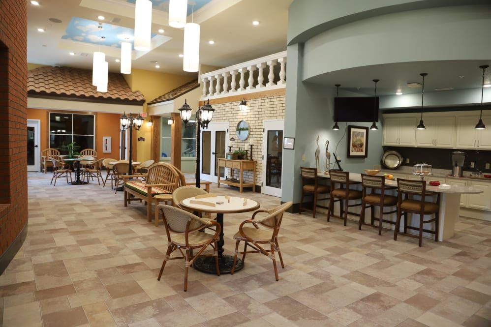 A cozy indoor cafeteria with tables and chairs, featuring decorative lighting and a warm ambiance.
