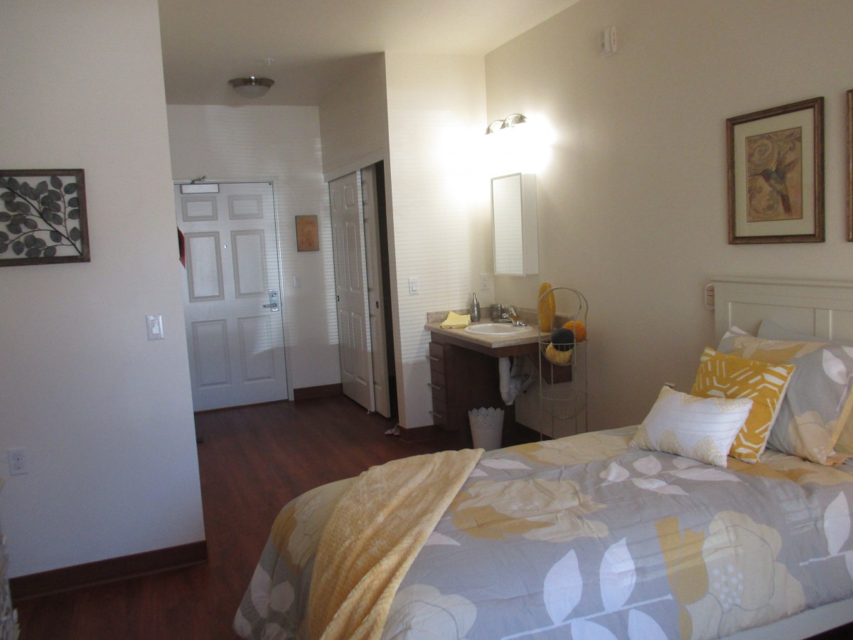 A cozy bedroom with a neatly made bed, soft lighting, and warm decor.