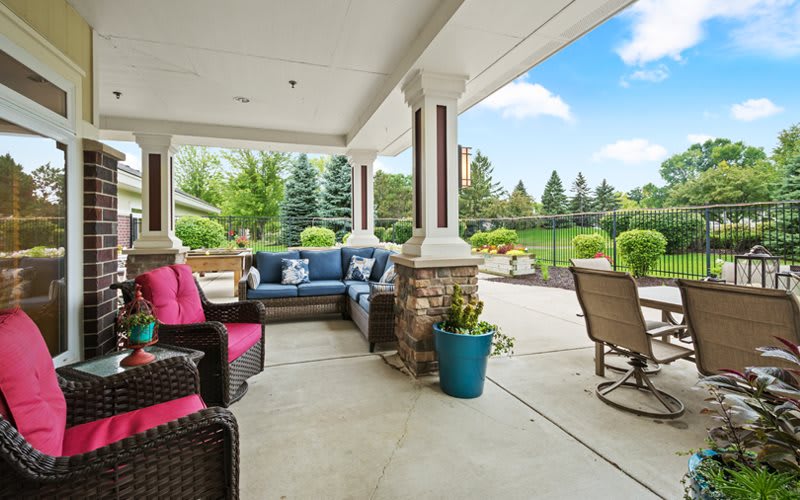 A cozy outdoor patio with comfortable seating and a beautiful garden view.