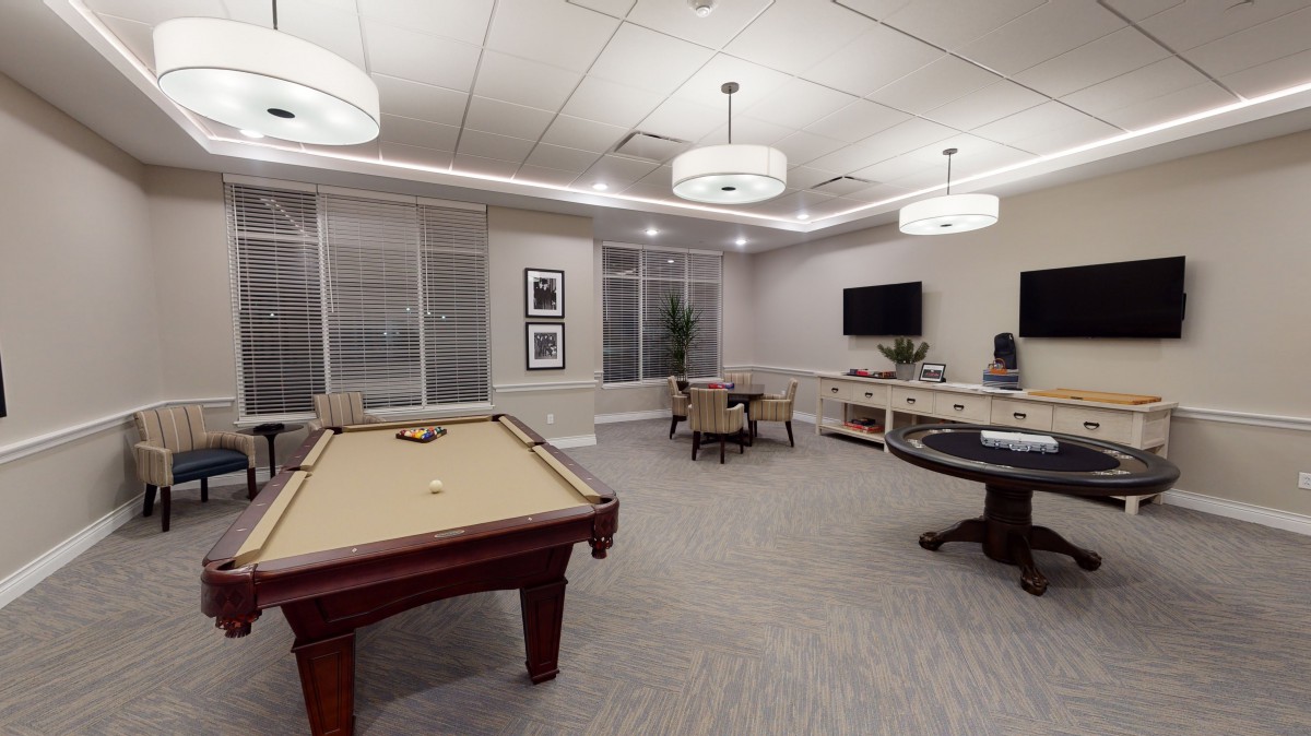 A modern recreation room featuring a pool table and a poker table.