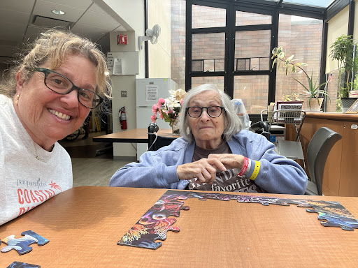 A joyful moment shared between two friends working on a puzzle together.