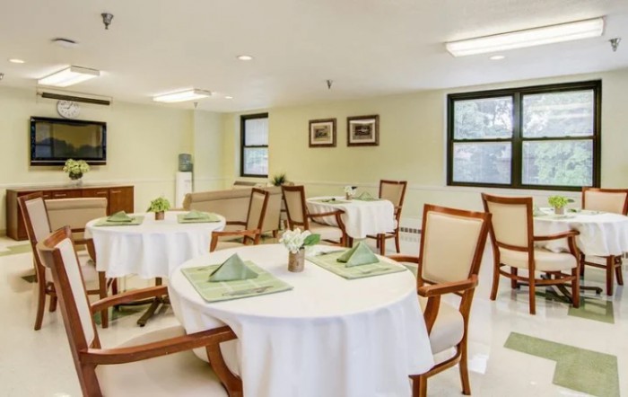 A neatly arranged dining room with tables and chairs set for a meal.