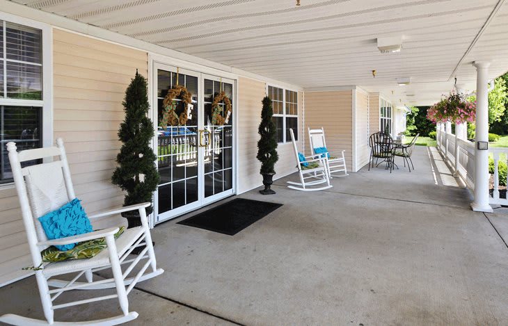 A welcoming porch with rocking chairs and decorative greenery.