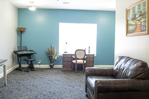 A cozy living space featuring a workspace with a desk and chair, complemented by a green accent wall.