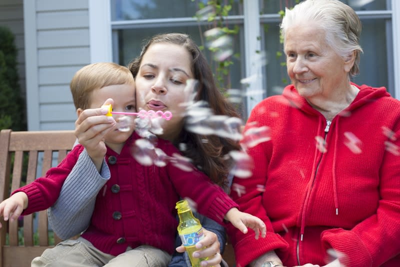 A family enjoying time together outdoors, blowing bubbles.