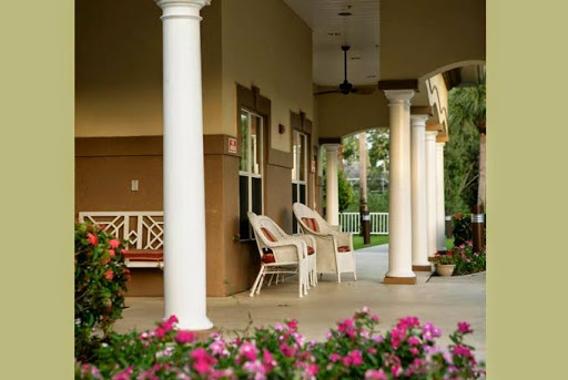 A serene porch adorned with blooming flowers and inviting chairs, perfect for a peaceful afternoon.