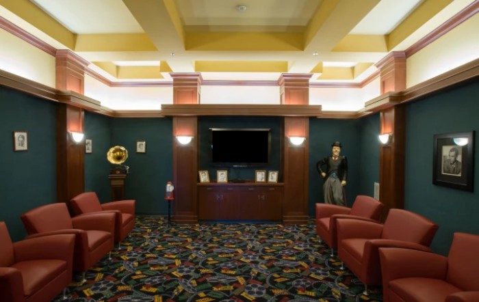A view of a lobby with comfortable seating, a television, and decorative lighting.
